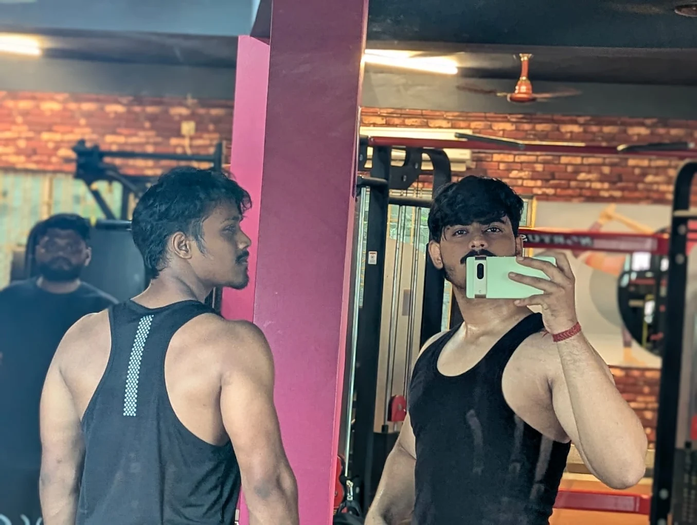 Personal trainer assisting member with correct form